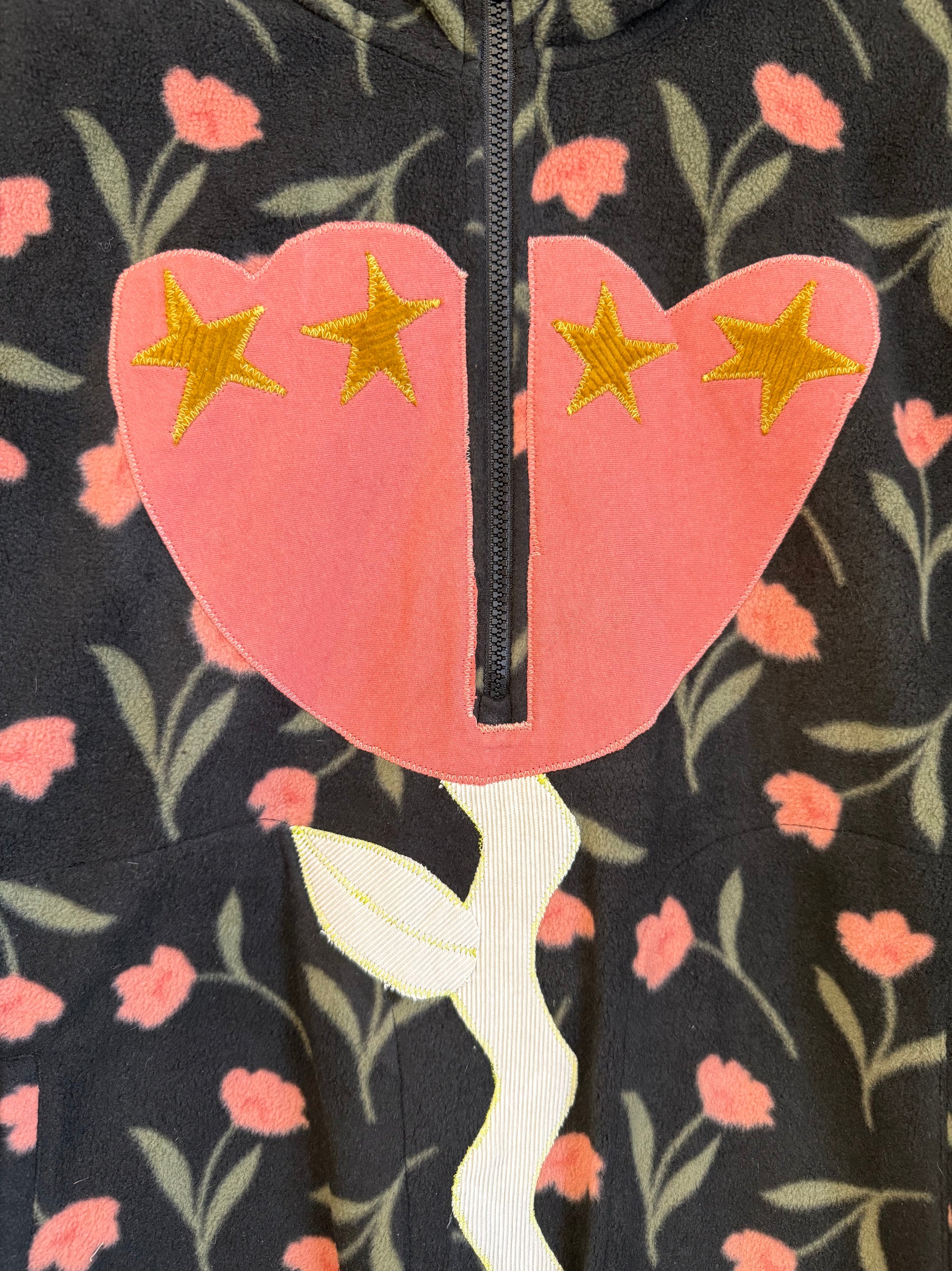 Close-up of a floral-patterned garment with a pink flower design and gold stars.