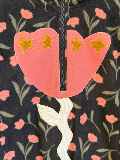 Close-up of a floral-patterned garment with a pink flower design and gold stars.